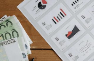 Banconote da 100 euro e un documento con dei grafici finanziari