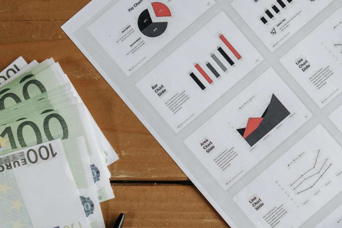 Banconote da 100 euro e un documento con dei grafici finanziari