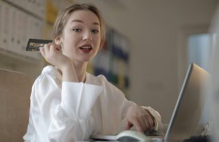 Ragazza che fa acquisti sul pc con una carta di credito