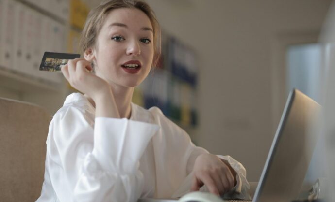 Ragazza che fa acquisti sul pc con una carta di credito