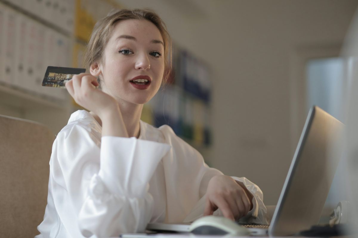 Ragazza che fa acquisti sul pc con una carta di credito