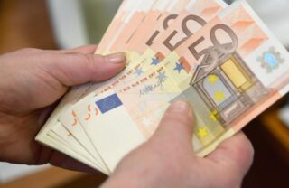 Impiegato bancario che conta banconote da 50 euro