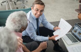 Due clienti anziani di fronte a un consulente finanziario