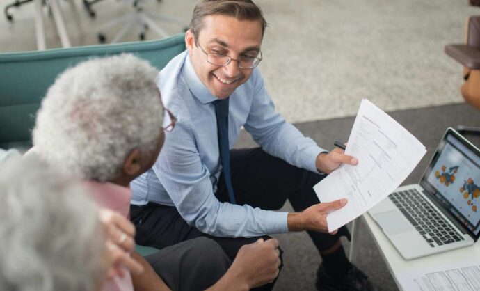 Due clienti anziani di fronte a un consulente finanziario