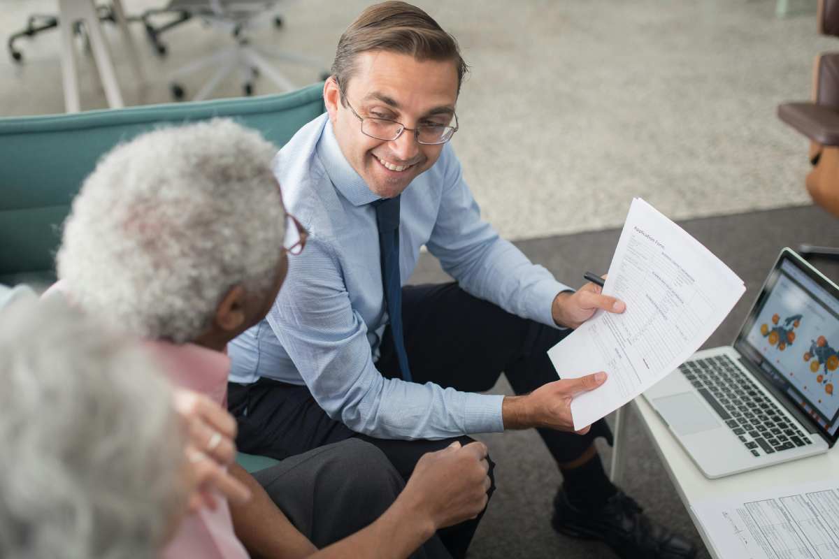 Due clienti anziani di fronte a un consulente finanziario
