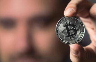 Un uomo con un bitcoin in mano