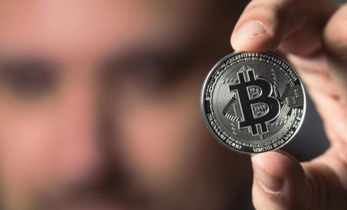 Un uomo con un bitcoin in mano